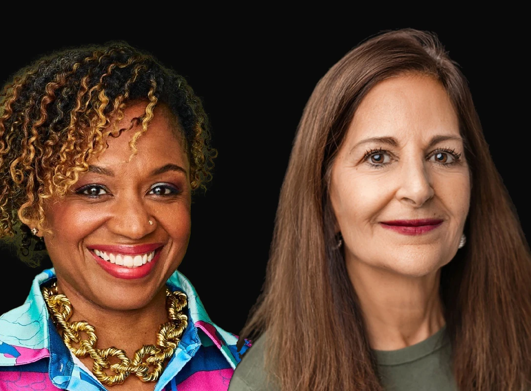 Two women posing in front of a black background