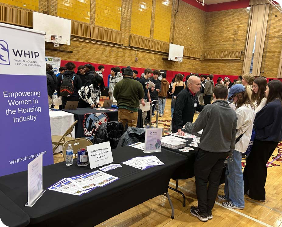 People interacting at a table with poster boards.
